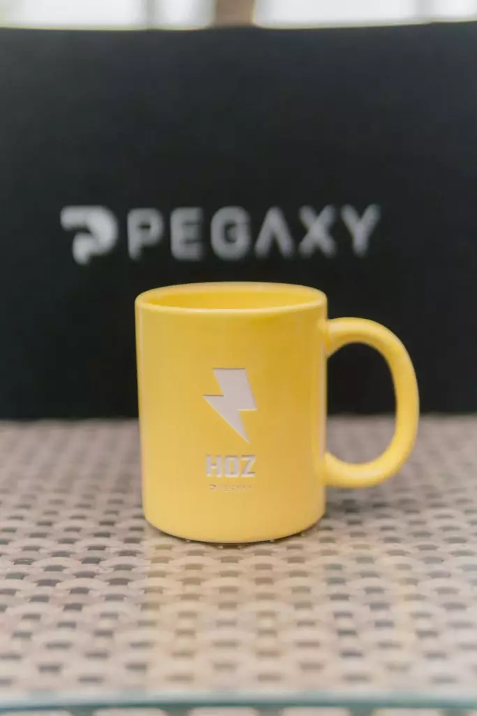A yellow Hoz mug from the merch box